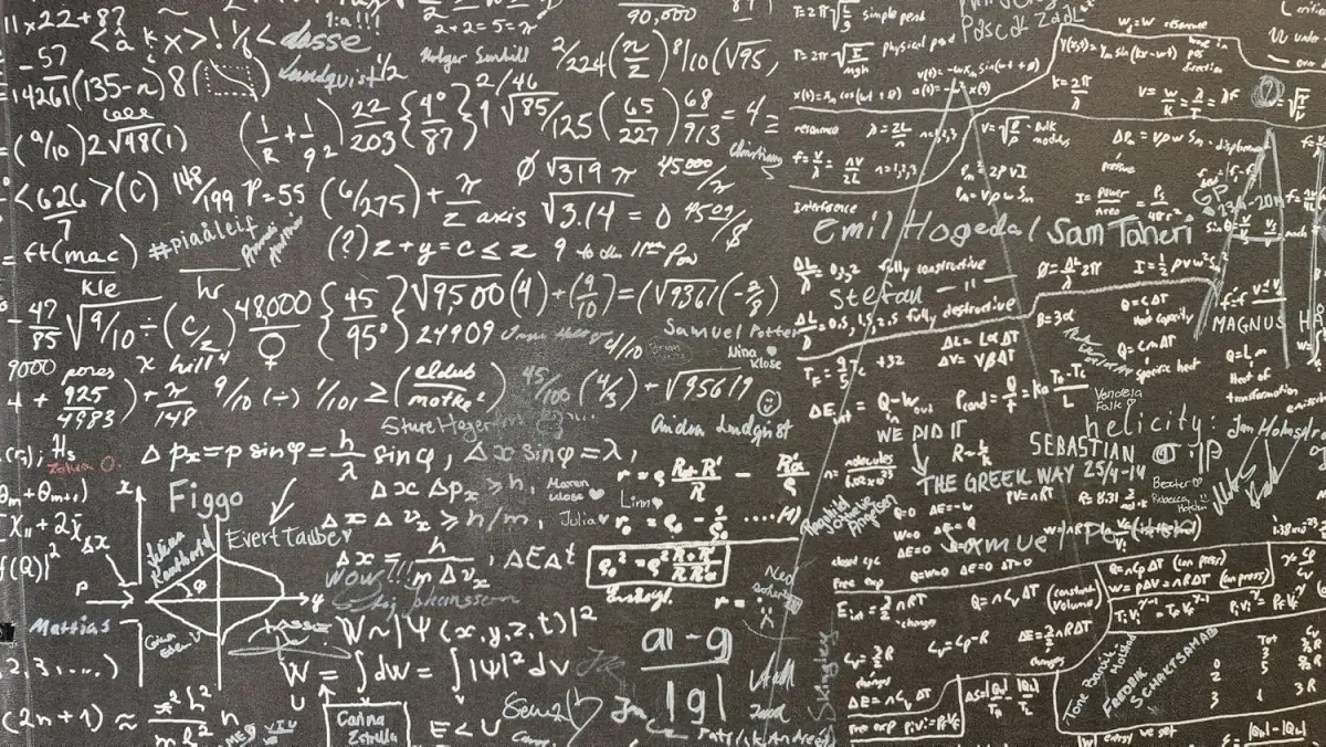 A chalkboard filled with various mathematical formulas, equations, and notes handwritten in white chalk.
