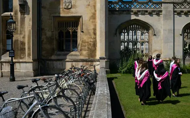 Graduates in gowns walking through a Cambridge courtyard